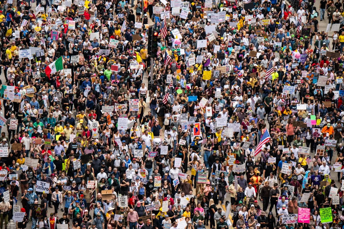 A large crowd holding signs at one of the "No Kings" protests